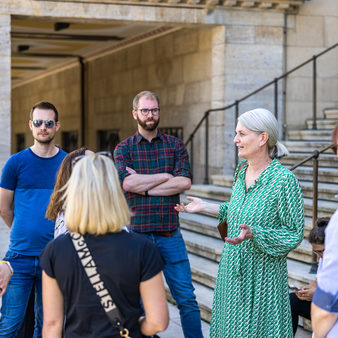 Stadtgäste während einer Führung stehen vor dem Museum